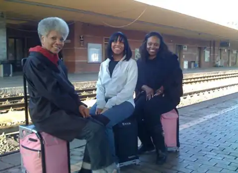 Travelers sitting on their ZÜCA cases at the Assisi train station