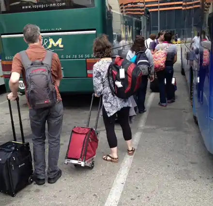 Travelers pulling ZÜCA luggage to the coach in Lyon